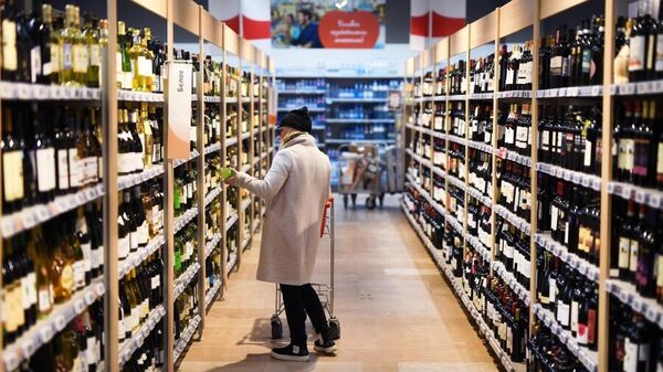 Покупательница в отделе алкогольной продукции в гипермаркете АШАН в торговом центре Капитолий в Москве